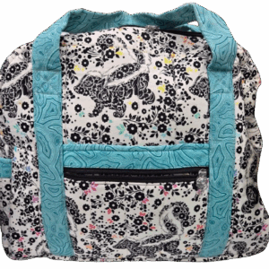A floral-patterned bag with teal straps and a front zipper pocket.