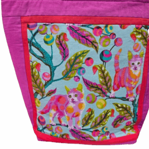 Colorful fabric with floral and animal patterns in pink and green hues.