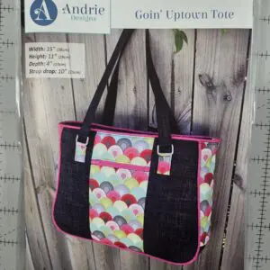 Handmade tote bag with colorful pattern and black straps.