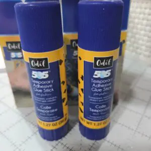Two blue UHU 3S glue sticks standing side by side.