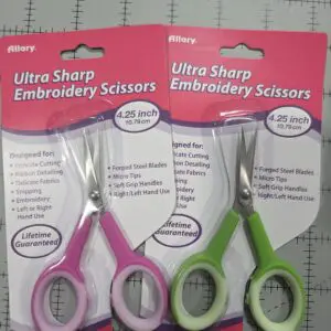Two pairs of ultra sharp embroidery scissors in pink and green handles.