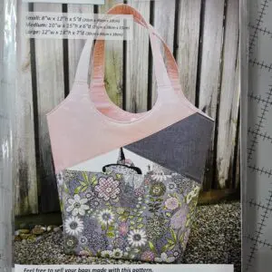 A handmade tote bag with floral and geometric fabric patterns.