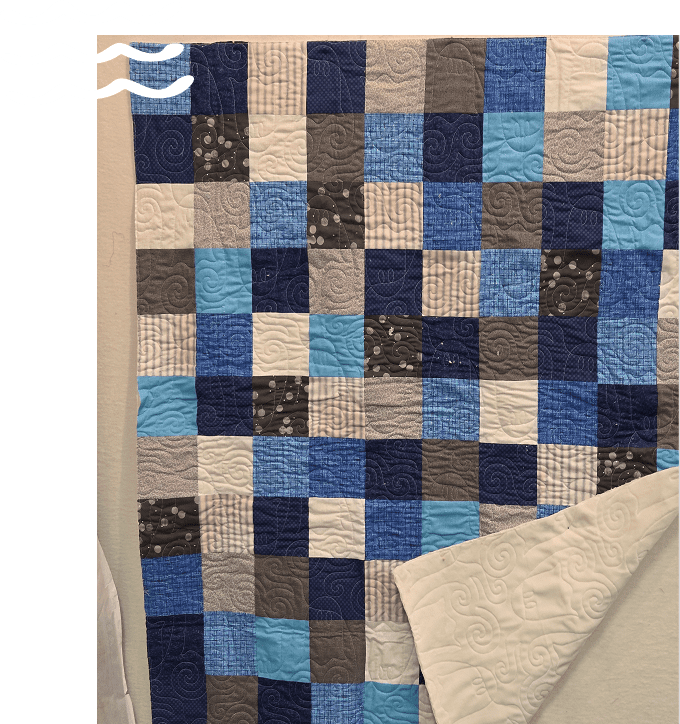 A handmade patchwork quilt with blue and beige squares.