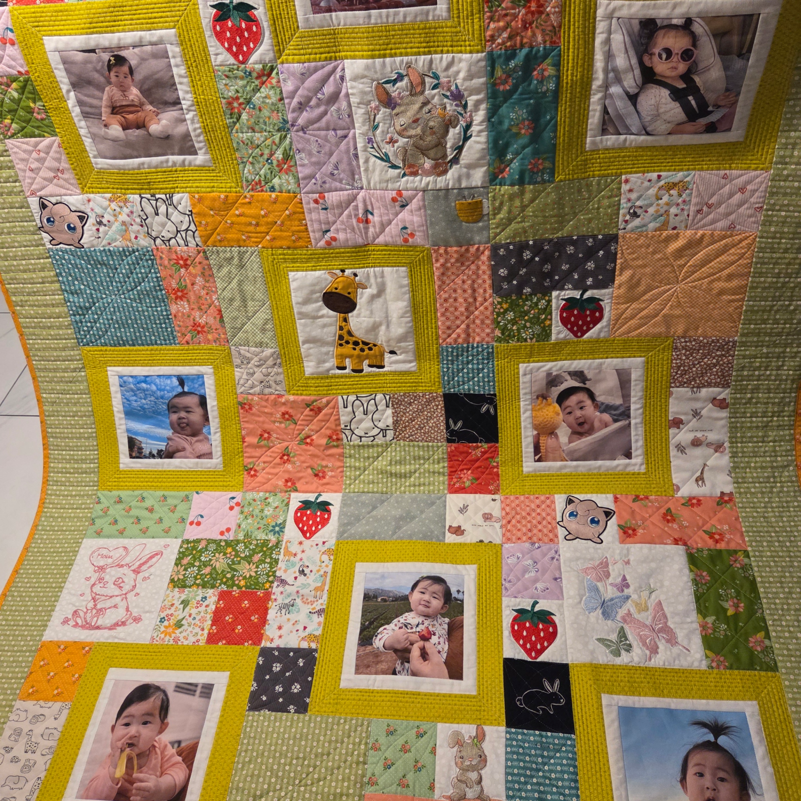 A colorful quilt featuring baby photos in bright frames.